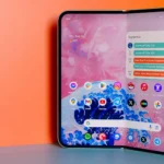 Điện thoại Google Pixel 9 Pro Fold đang mở ra, đặt trước phông nền màu cam.