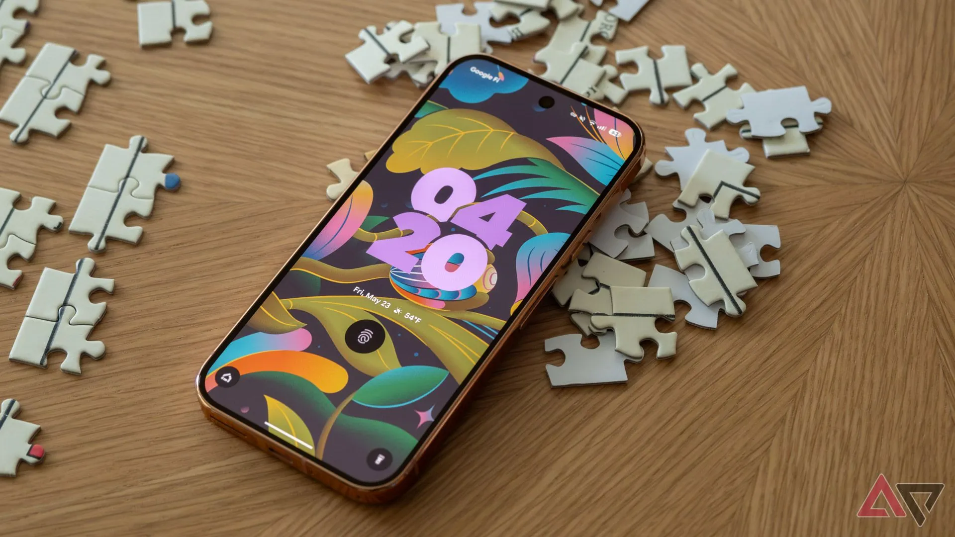 Điện thoại Google Pixel 9 Pro với màn hình khóa Material 3 đặt trên các mảnh ghép hình.