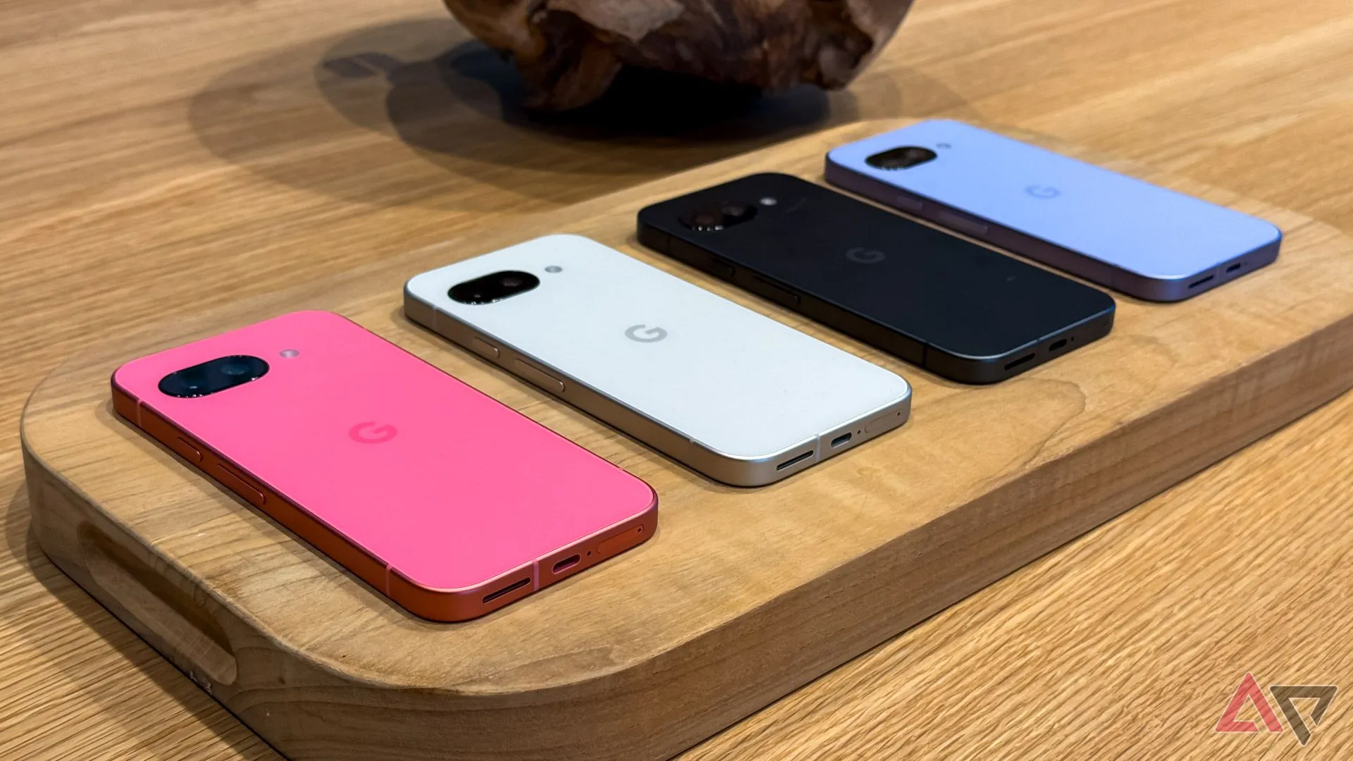Điện thoại Google Pixel 9a với bốn màu khác nhau đặt úp mặt trên bàn