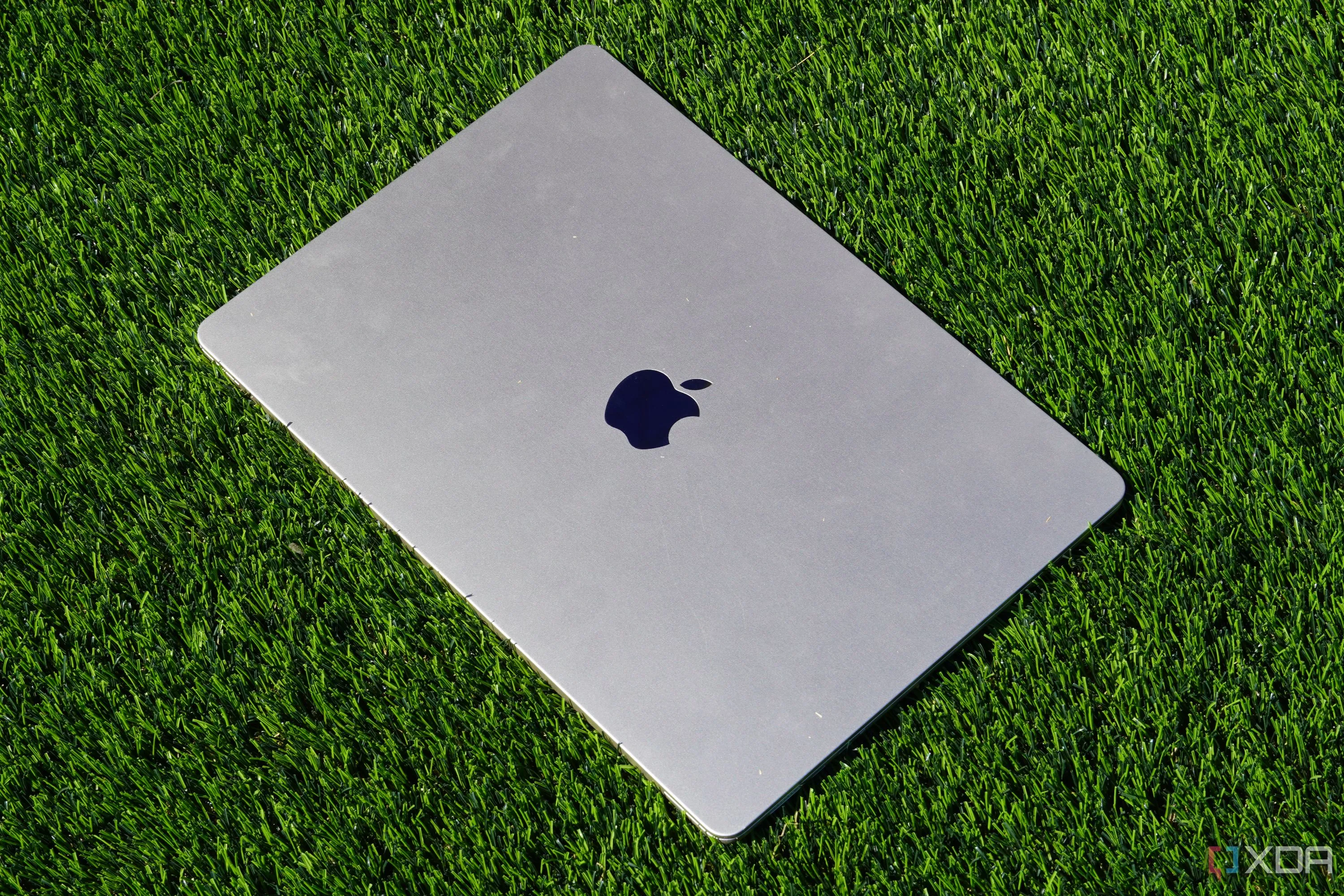 MacBook Air 15 inch màu Starlight đặt trên thảm cỏ nhân tạo, thể hiện sự sang trọng và tính di động.