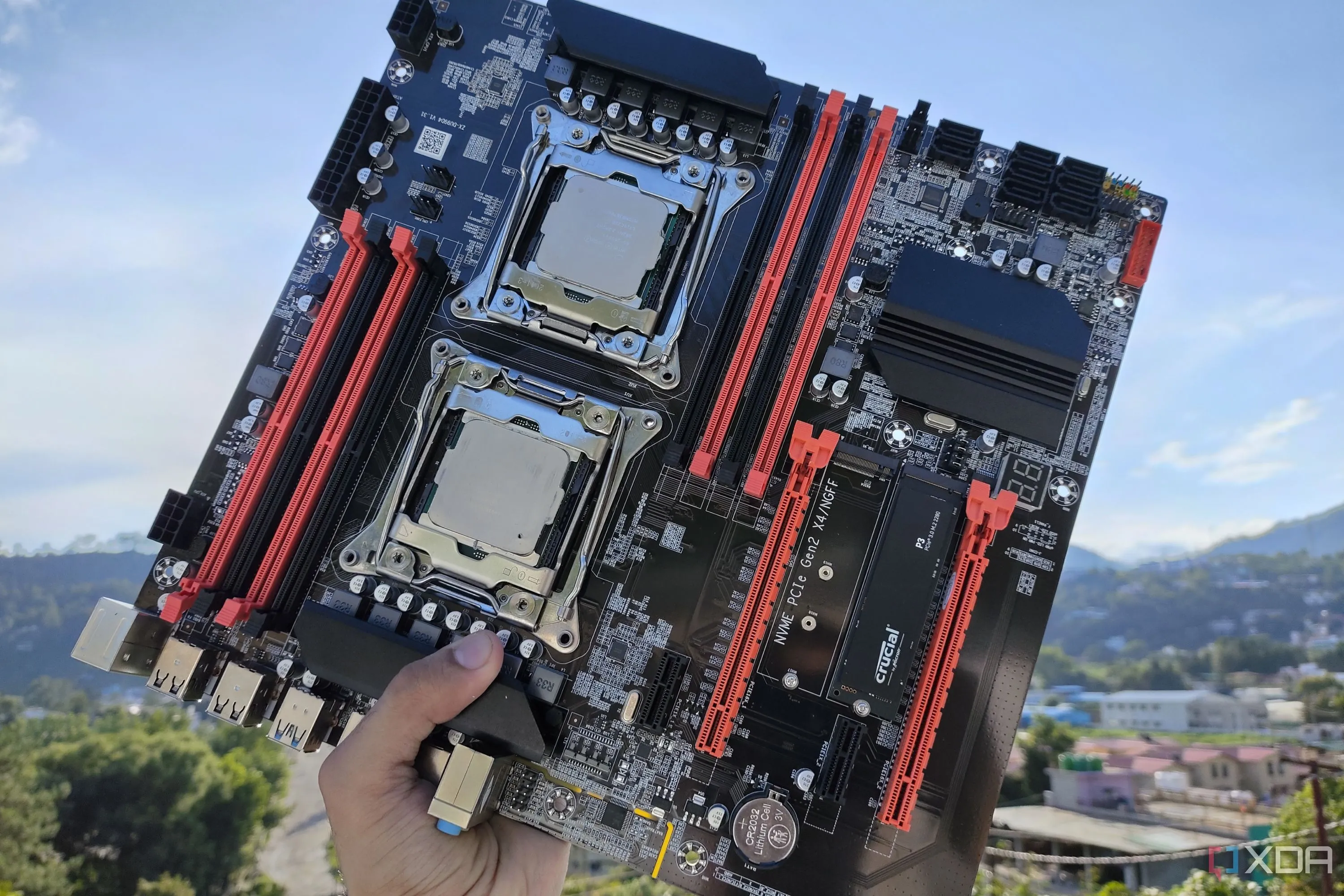 Người dùng đang cầm bo mạch chủ server X99, tập trung vào khu vực VRM và chipset cần tản nhiệt
