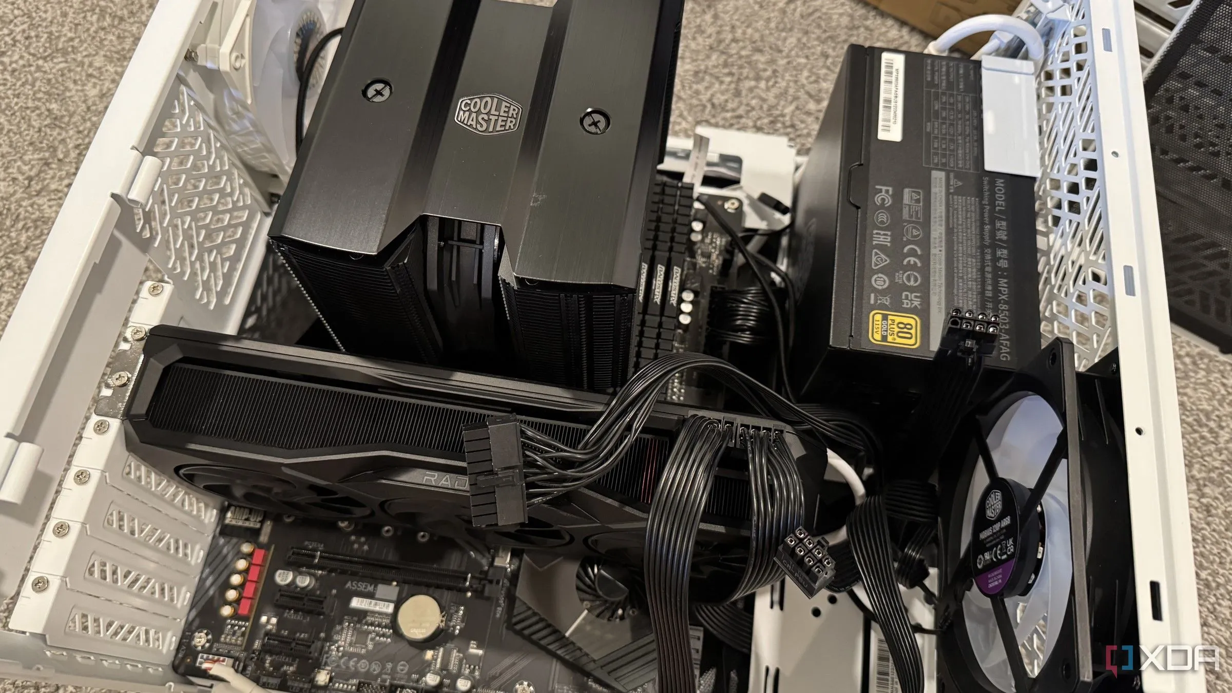 Bên trong một case máy tính đang được lắp ráp, các cáp GPU được cắm vào, làm nổi bật không gian hạn chế và thách thức tản nhiệt trong PC SFF.