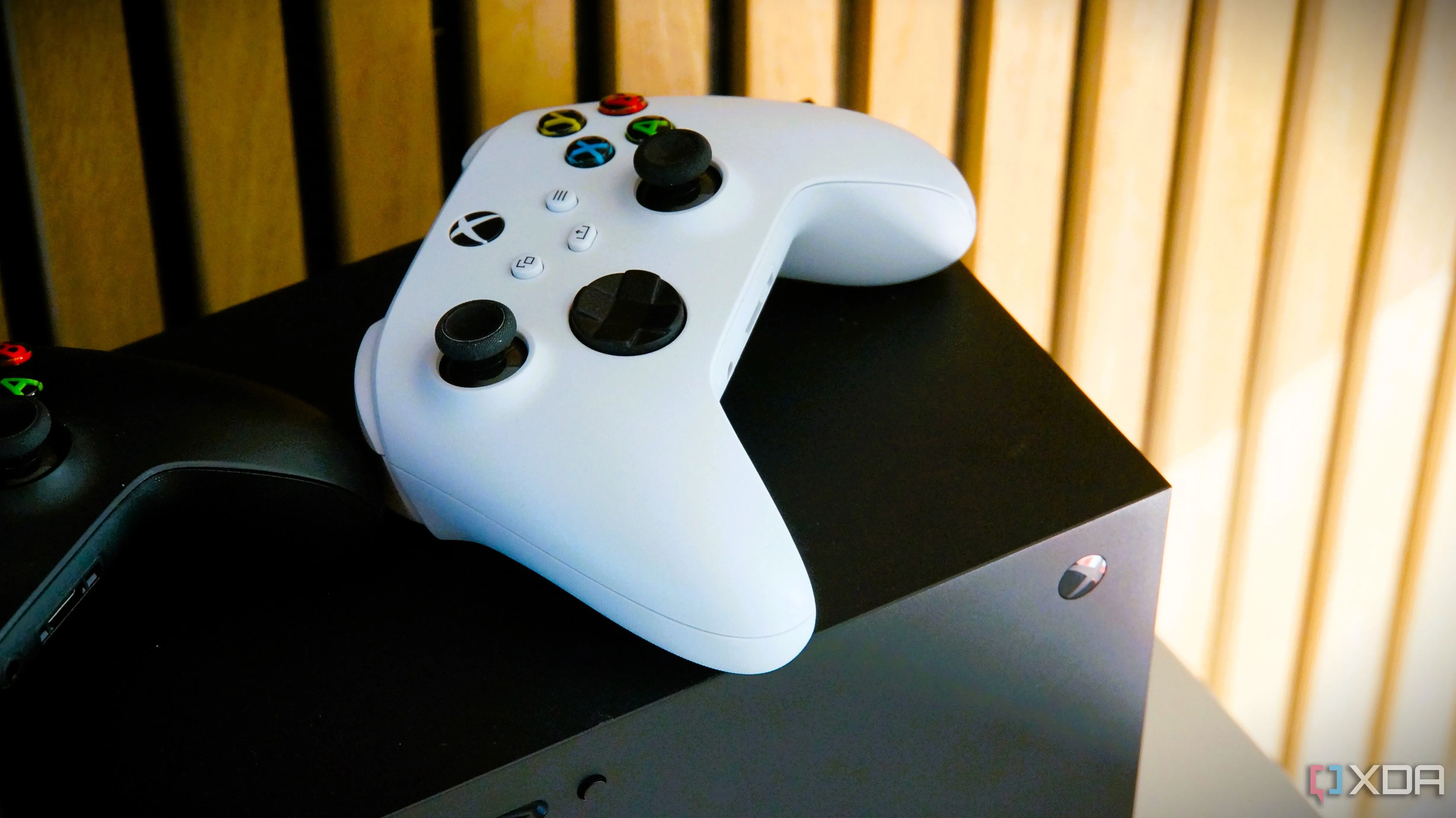 Bộ điều khiển Xbox màu trắng đặt trên console Xbox Series X, thể hiện sự cạnh tranh của console với PC gaming