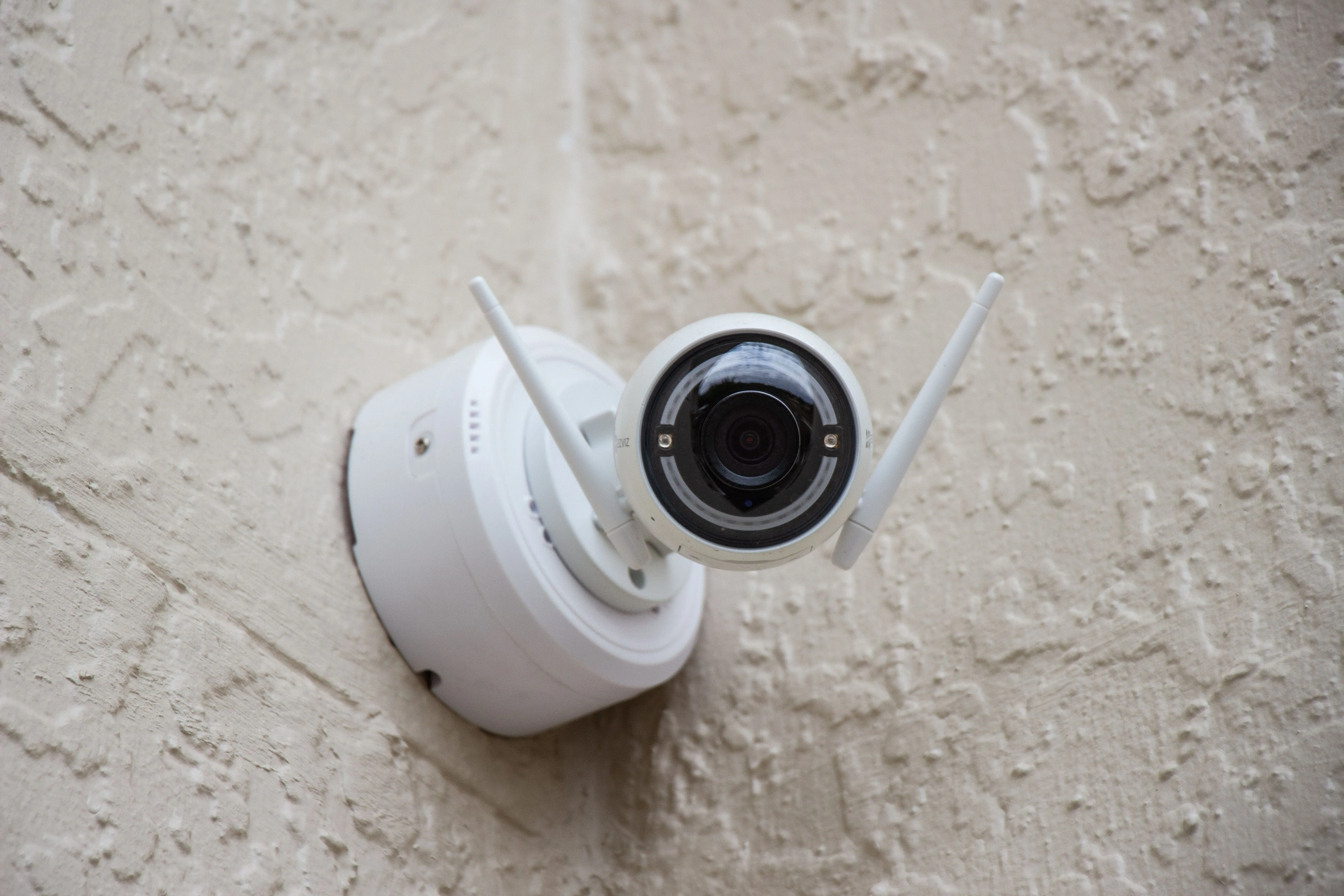Camera an ninh không dây gắn trên tường, tượng trưng cho hệ thống giám sát tại nhà cần Port Forwarding để truy cập từ xa