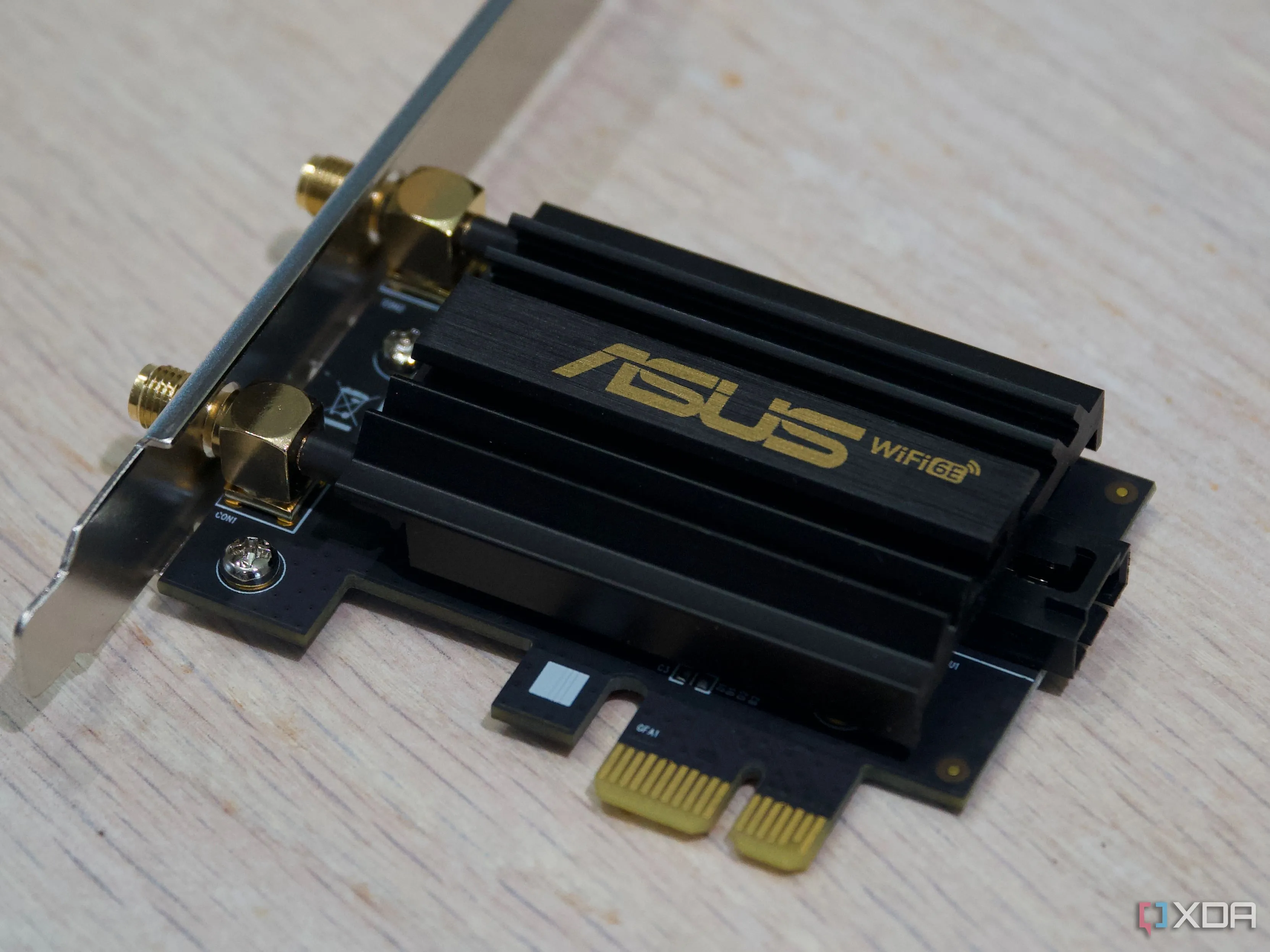 Card Wi-Fi PCIe Asus PCE-AXE59BT với tản nhiệt, đại diện cho bộ chuyển đổi Wi-Fi gắn trong