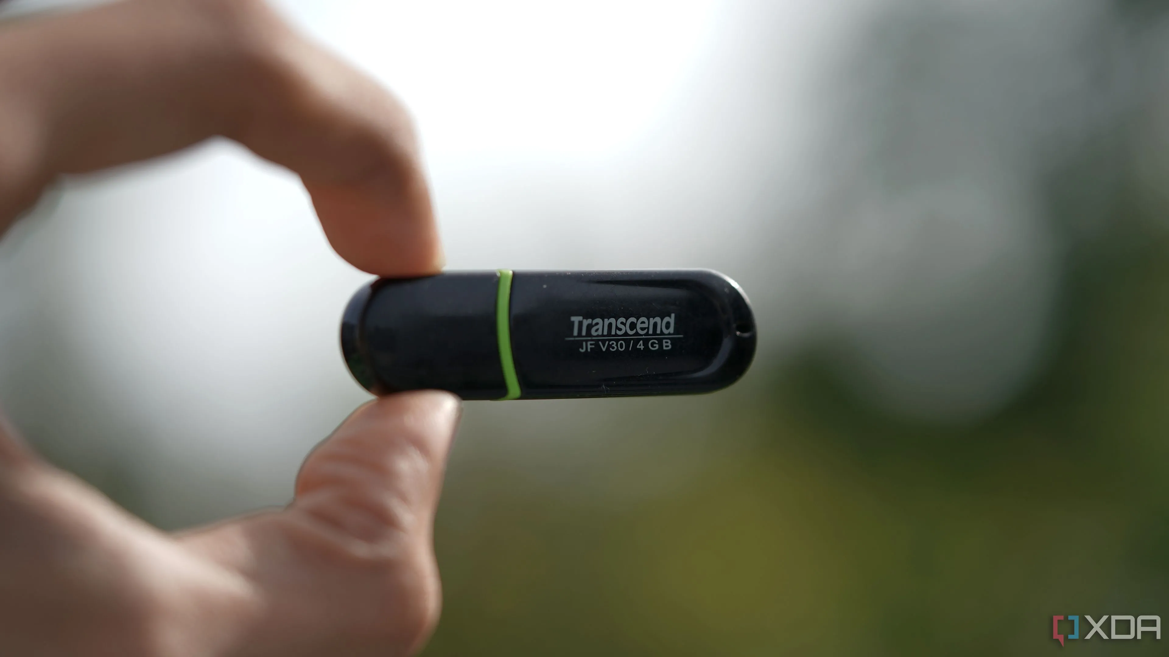Chiếc USB Flash Drive 4GB thương hiệu Transcend nhỏ gọn được giữ trên tay, gợi nhớ về thời kỳ phổ biến của các thiết bị lưu trữ di động dung lượng thấp