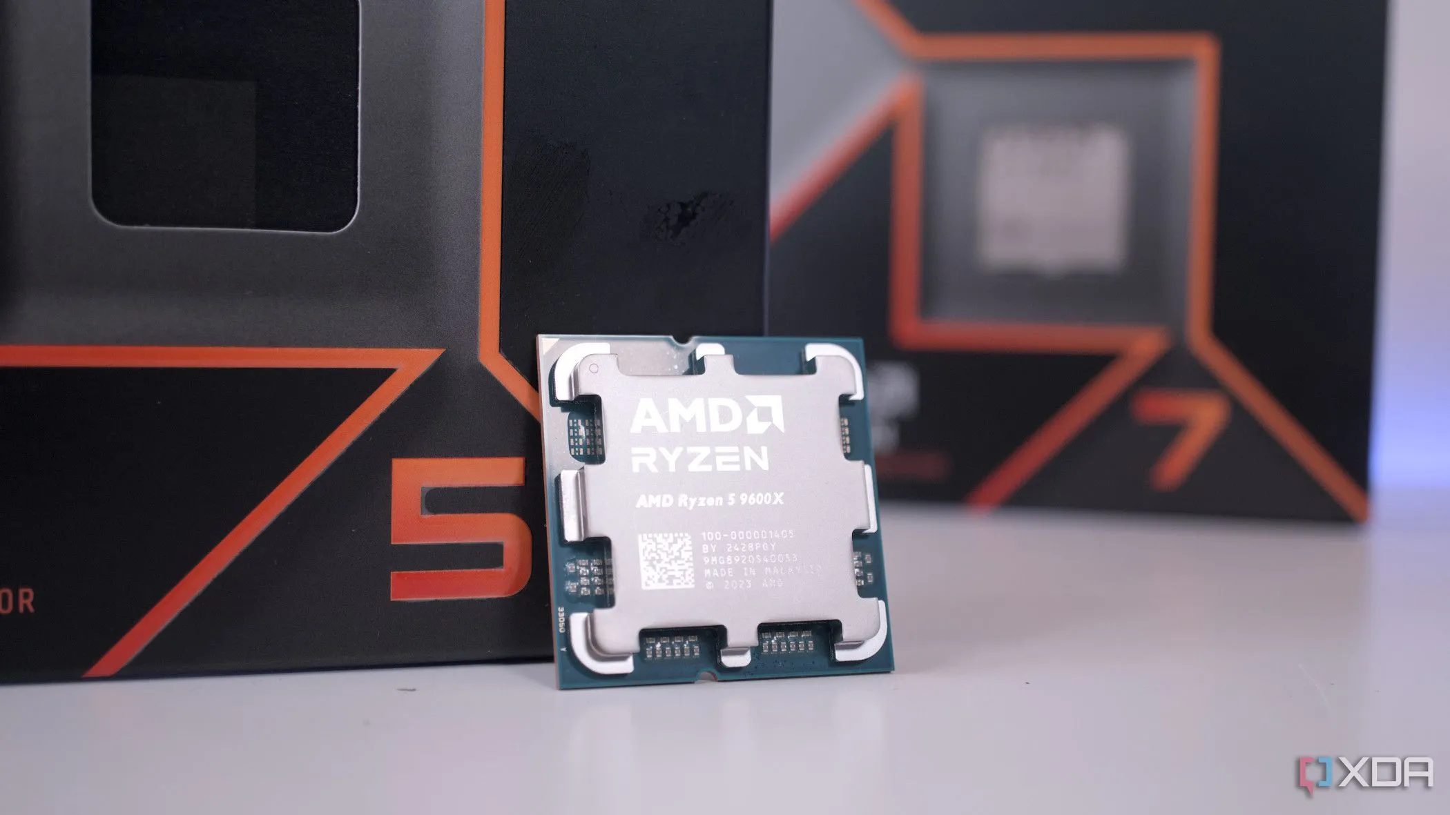 Chip CPU AMD Ryzen 5 9600X nổi bật phía trước hộp Ryzen 7, tượng trưng cho thế hệ vi xử lý Zen 5 mạnh mẽ
