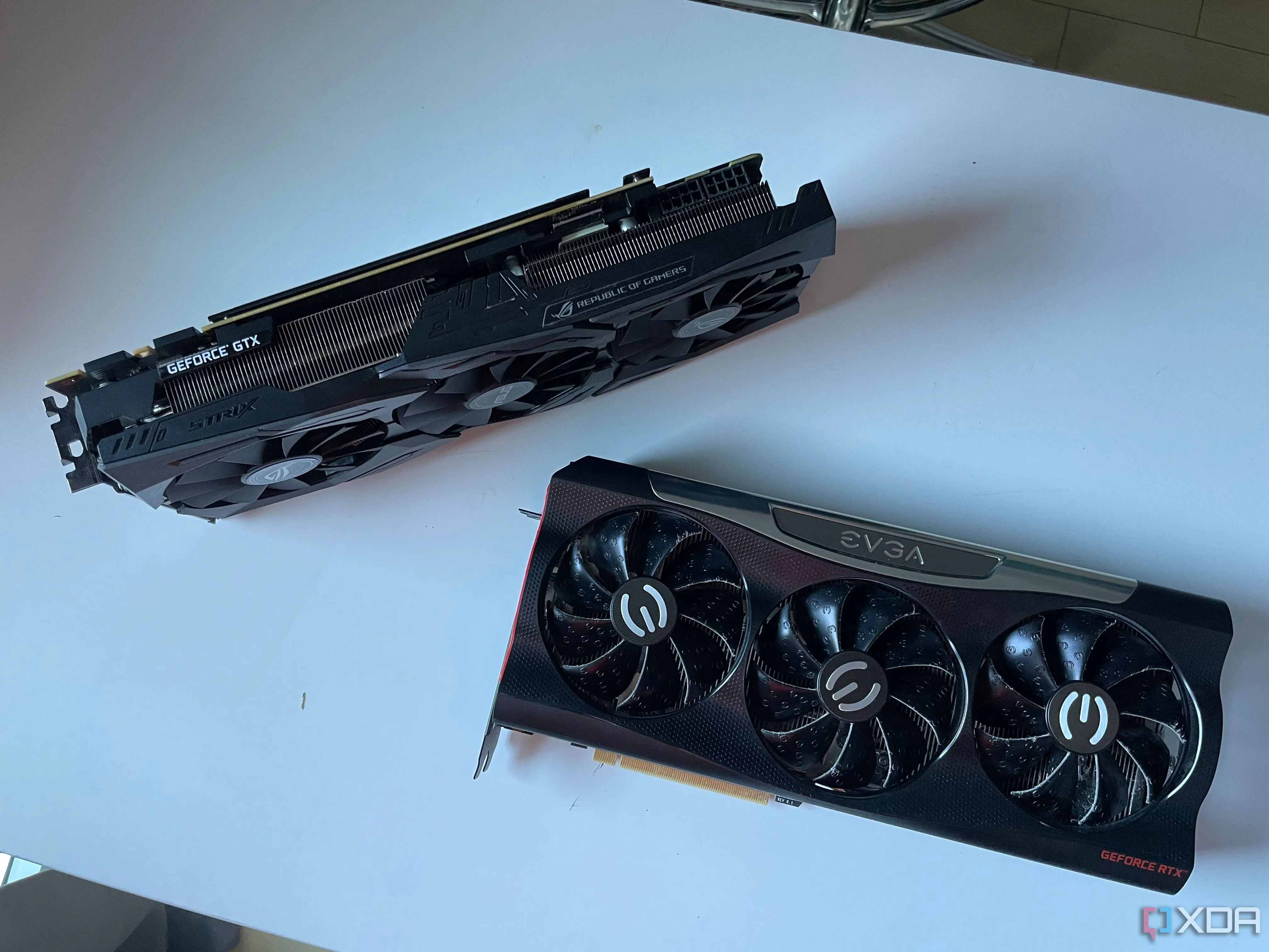 Hai card đồ họa cao cấp ASUS STRIX 1080ti và EVGA RTX 3080 đặt trên bàn, minh họa cho việc kiểm tra các hư hại ngoại hình khi mua linh kiện PC cũ.