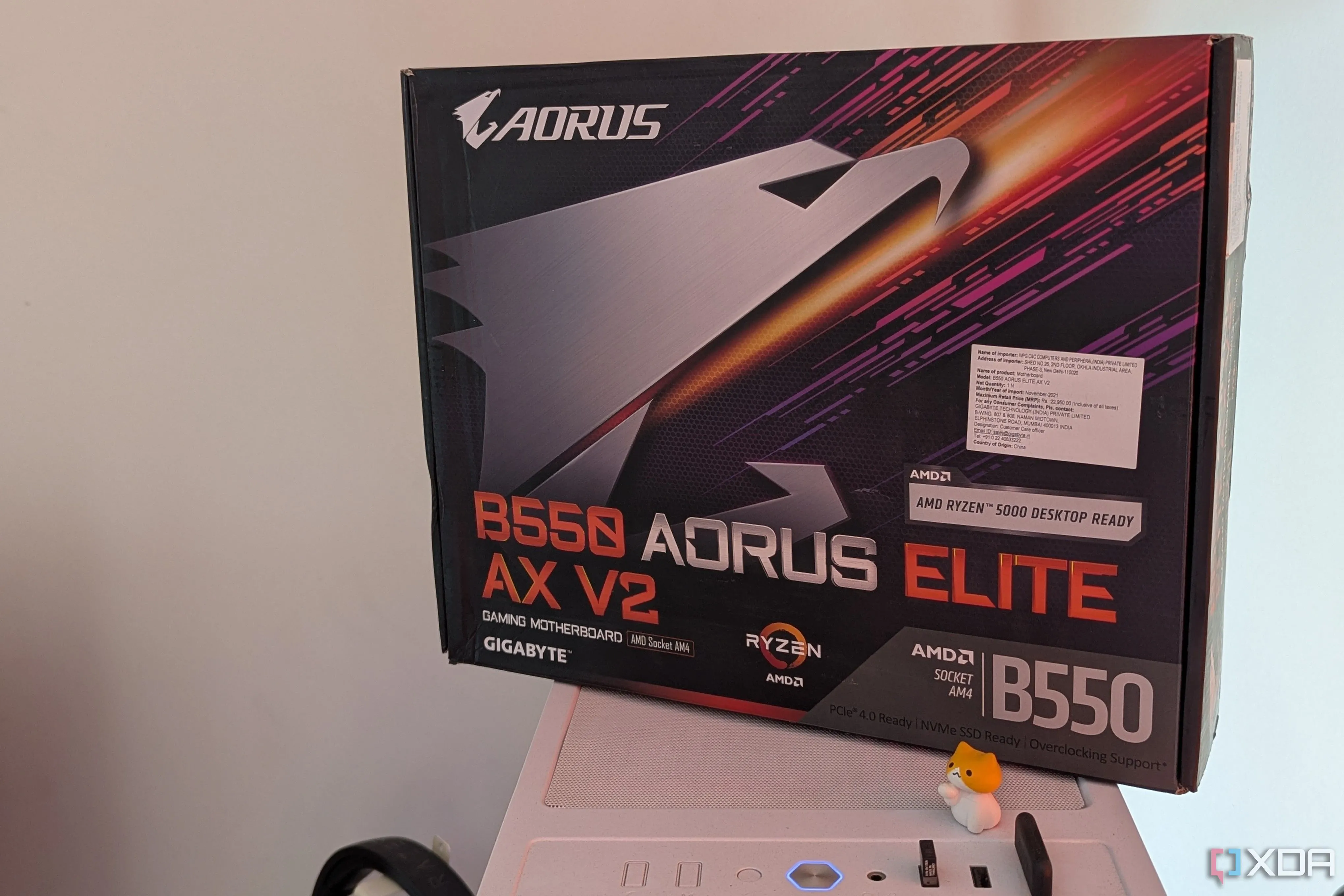 Hộp mainboard Gigabyte B550 Aorus Elite AX V2 đặt trên vỏ máy tính màu trắng, đại diện cho khoản chi tiêu mainboard AM4 đắt đỏ