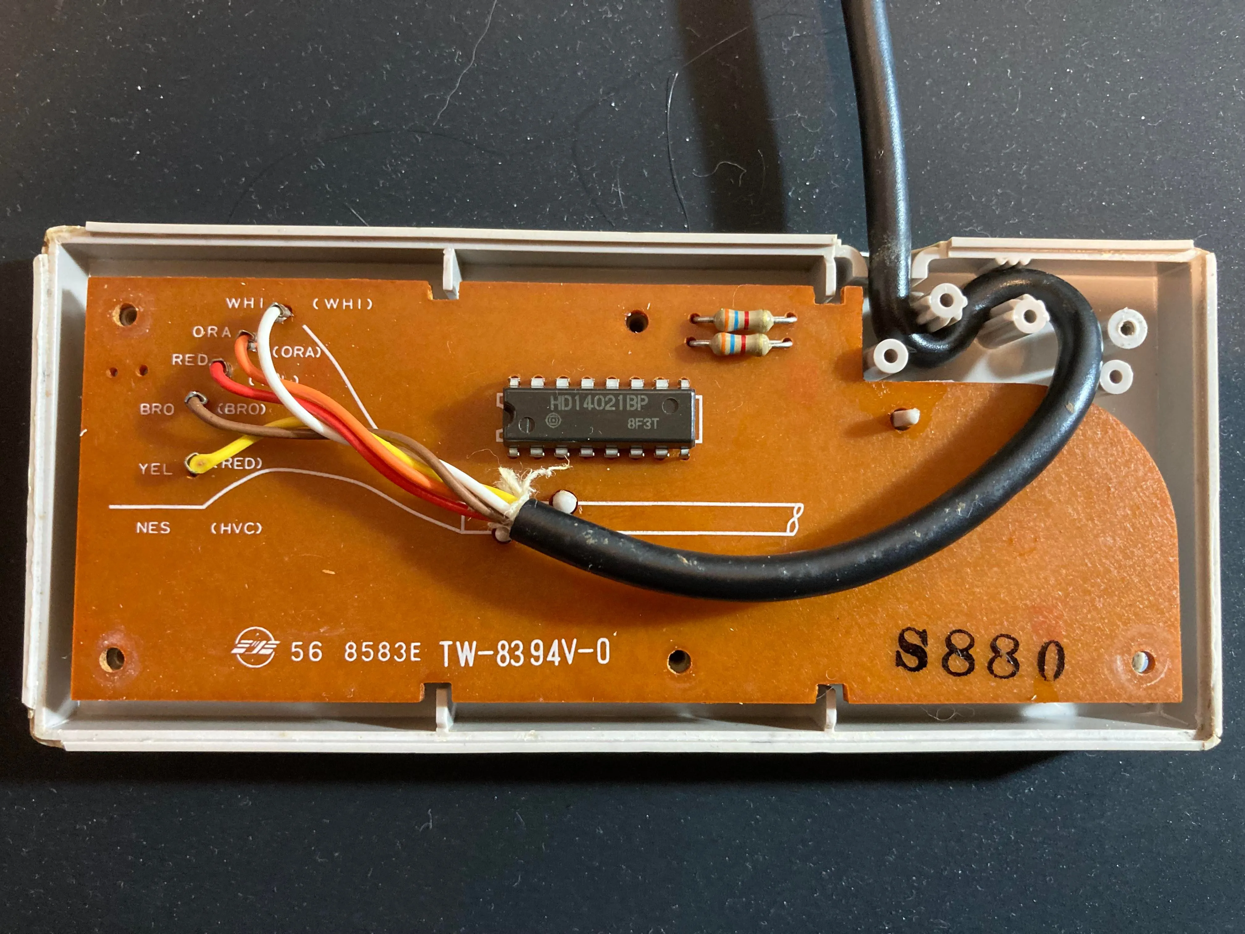 Mặt sau của bo mạch PCB tay cầm NES, với các đường mạch đồng và điểm hàn cáp.