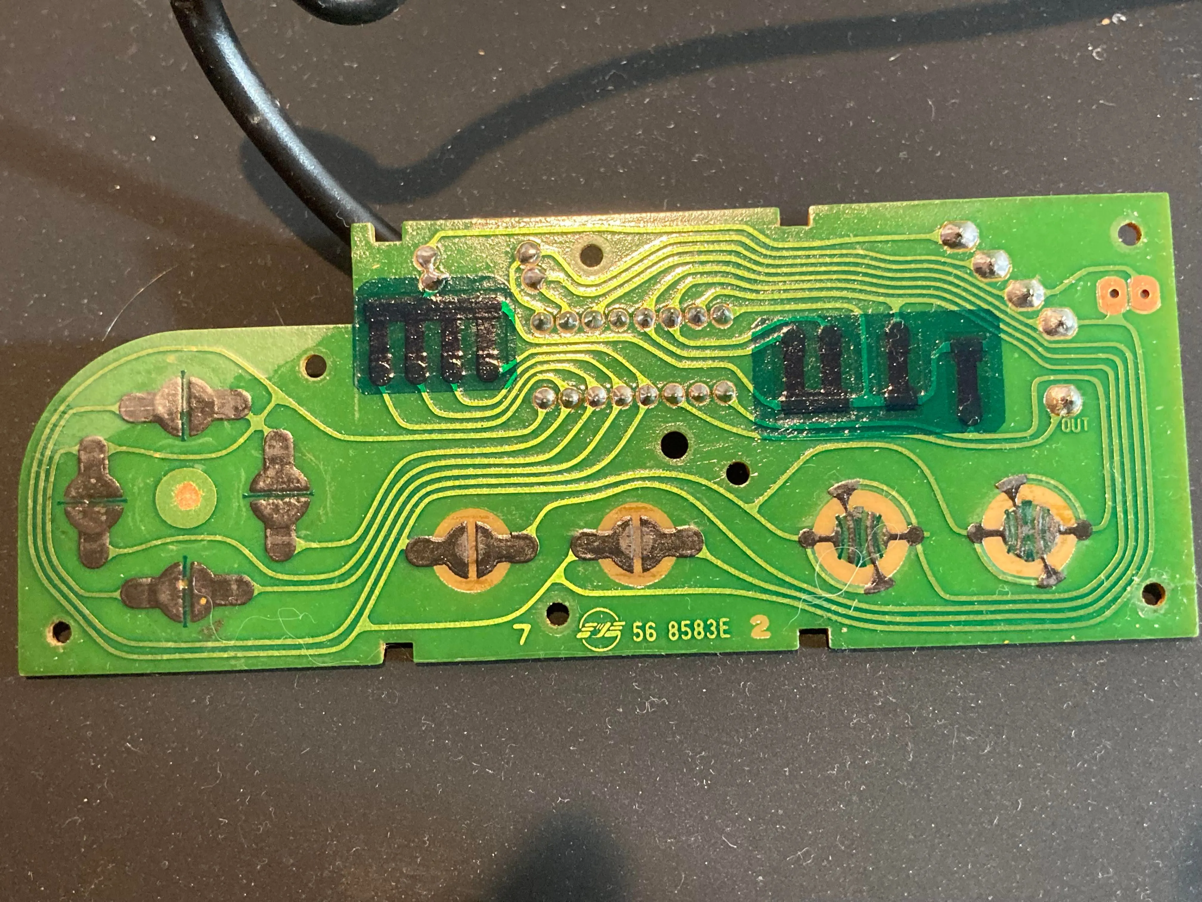Mặt trước của bo mạch PCB tay cầm NES, hiển thị các tiếp điểm nút bấm và thanh ghi dịch.