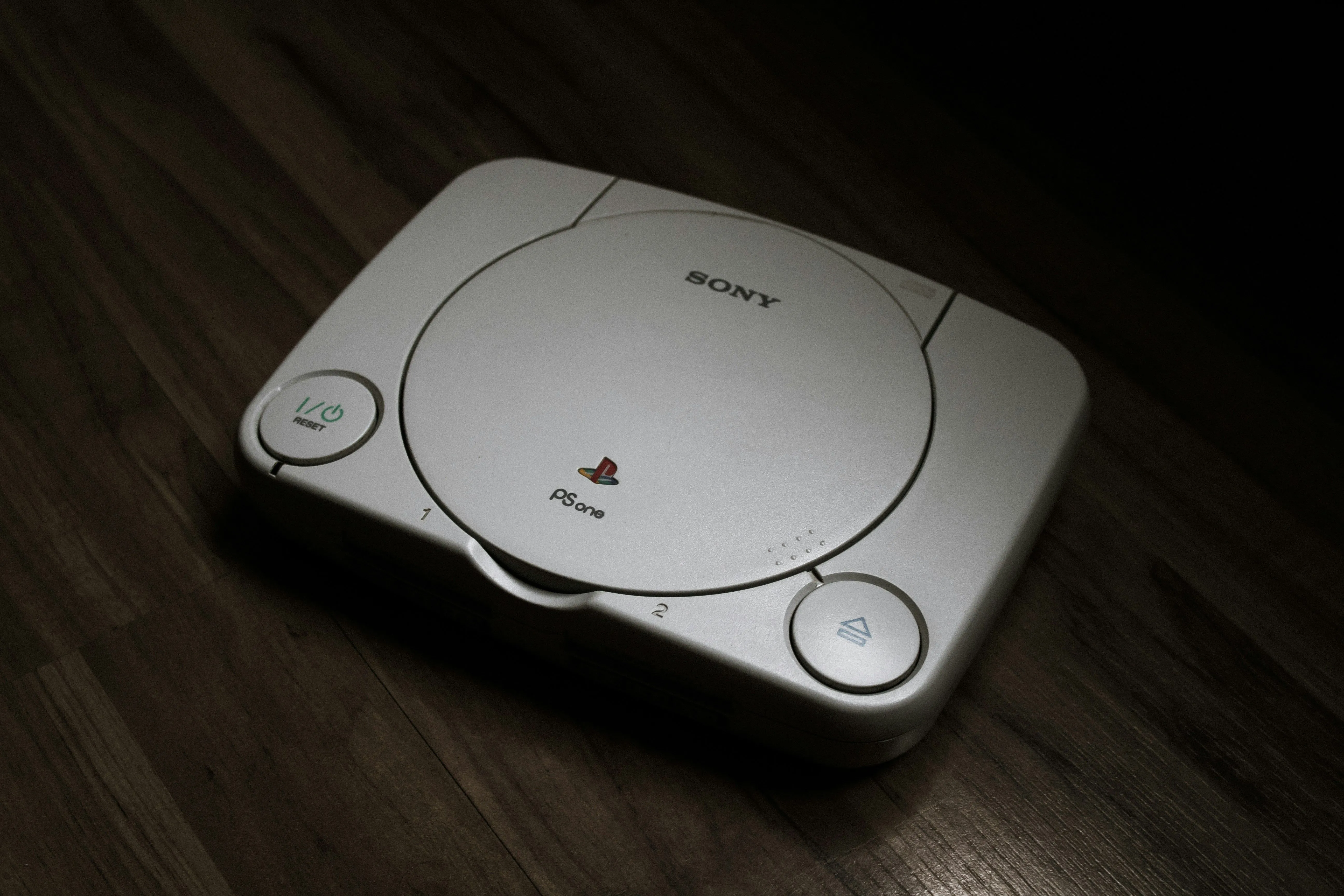 Máy chơi game PlayStation 1 (PS1) đặt trên sàn gỗ, đánh dấu kỷ nguyên mới của console