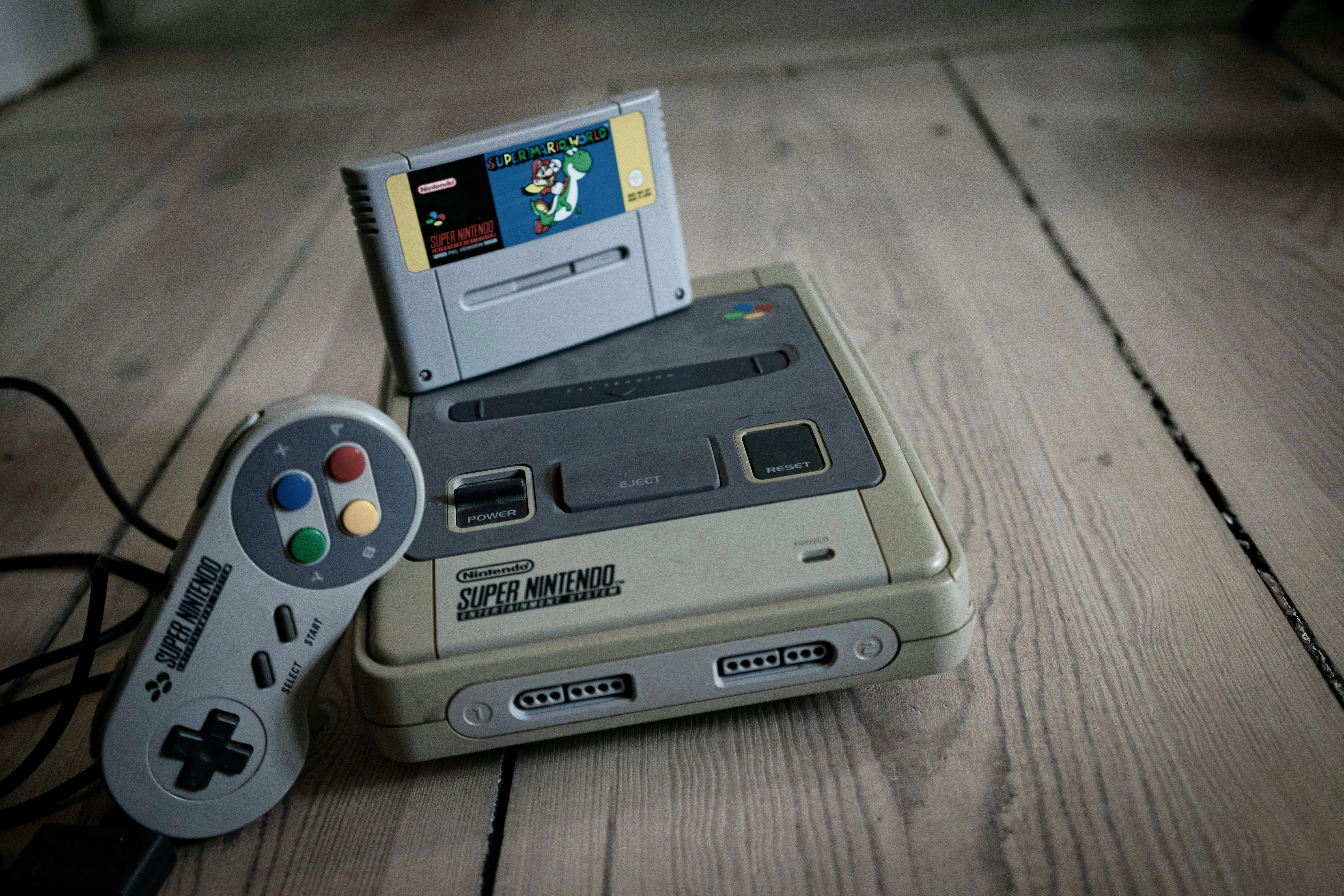 Máy chơi game Super Nintendo Entertainment System (SNES) và một tay cầm điều khiển.