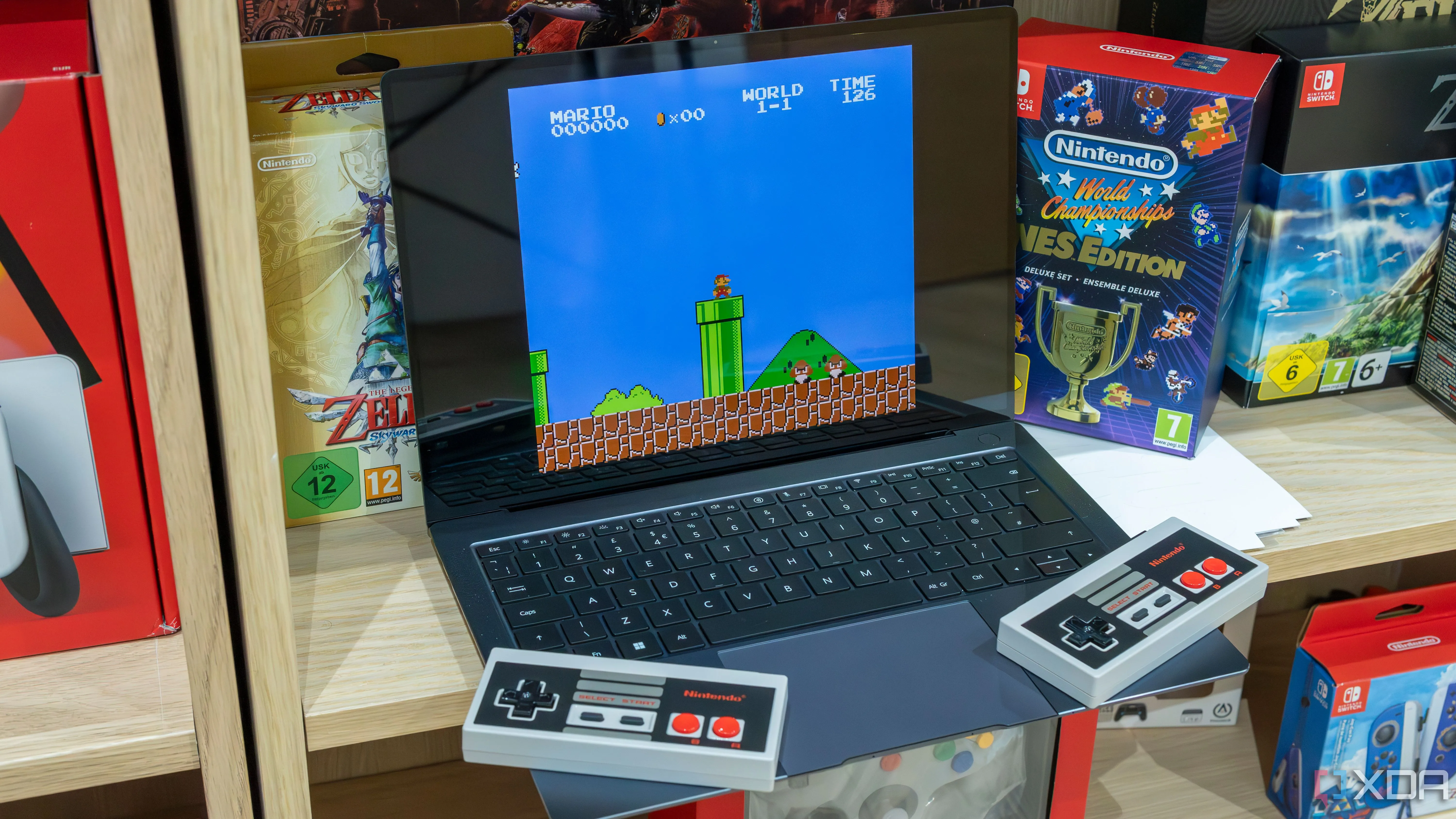 Một chiếc laptop Windows 11 đang chạy game Super Mario Bros. qua trình giả lập, với hai tay cầm NES không dây.