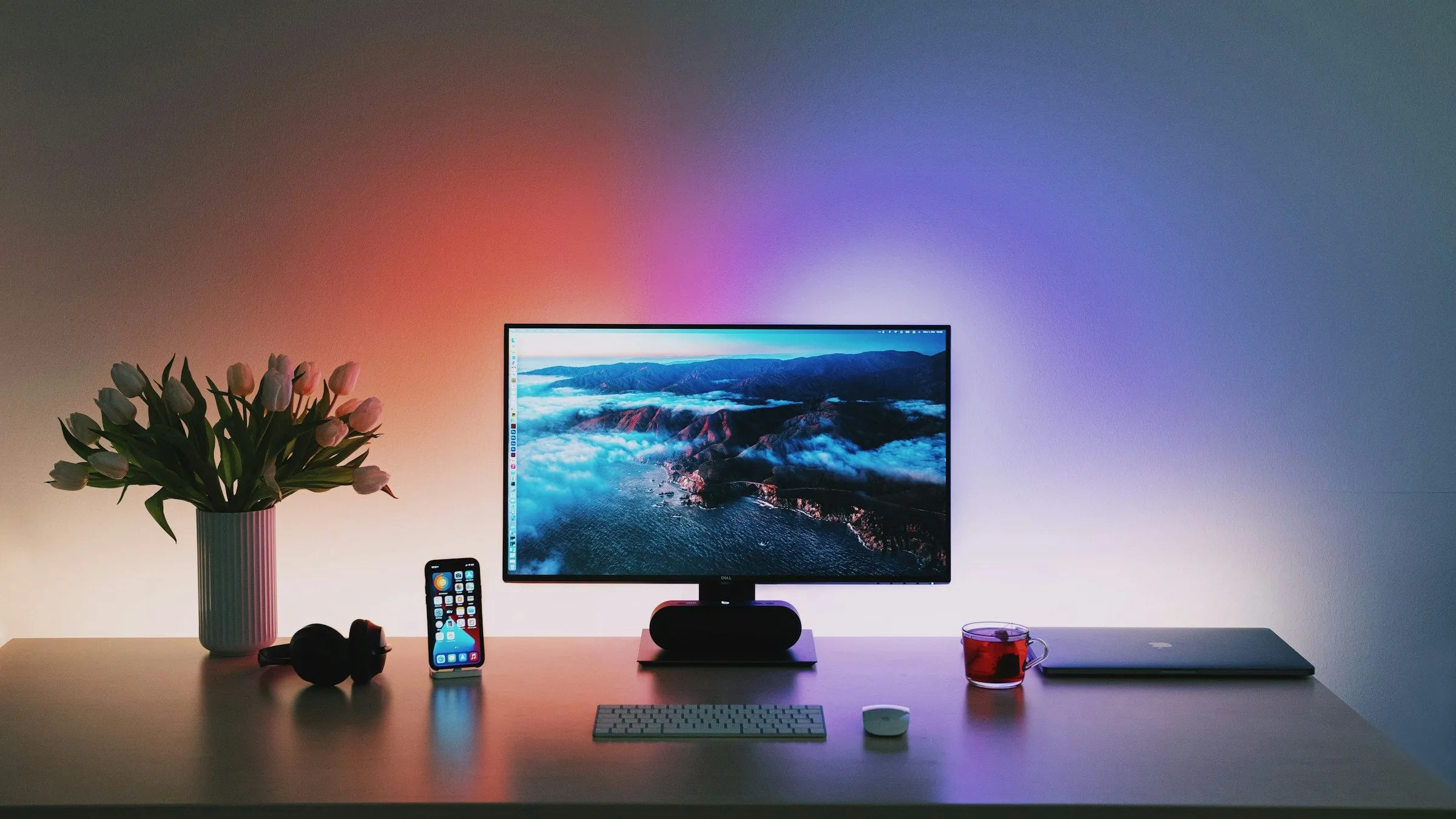 Một góc làm việc PC gọn gàng với ánh sáng dịu nhẹ phía sau màn hình, nhấn mạnh tầm quan trọng của việc đi dây cáp