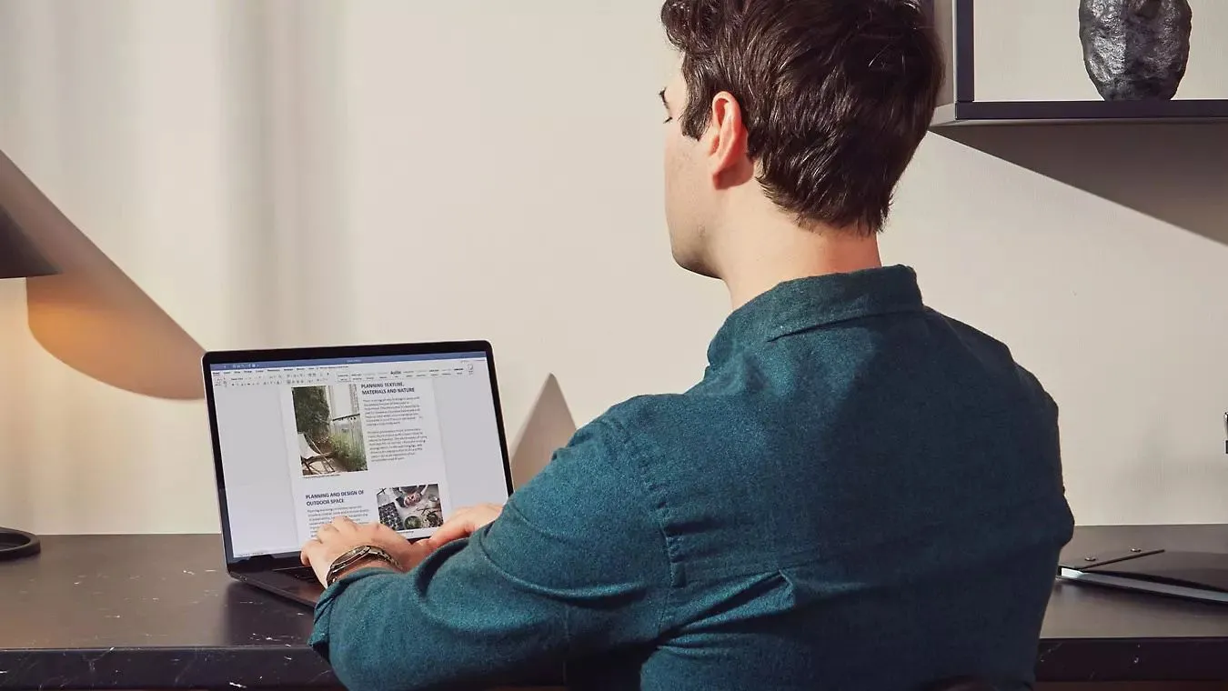 Một người đàn ông làm việc trên máy tính với tài liệu Microsoft Word, thể hiện sự quen thuộc và gắn bó với phần mềm văn phòng.