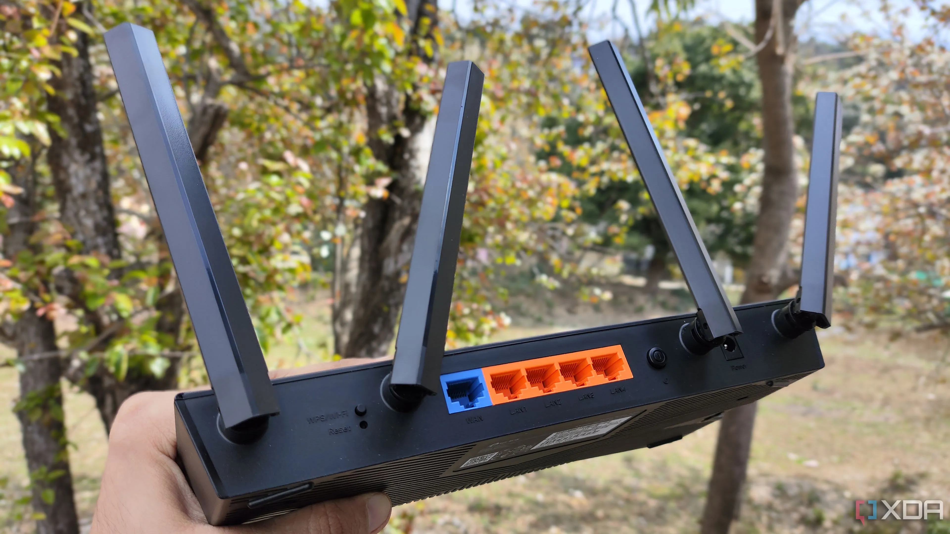 Một người đang cầm router TP-Link, gợi nhắc về việc cần kiểm tra và vô hiệu hóa tính năng WPS để tăng cường an ninh mạng.
