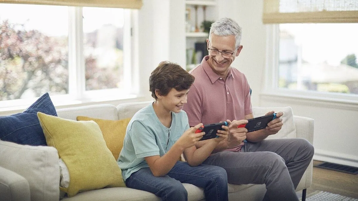 Người cha và con trai cùng chơi game trên Nintendo Switch, thể hiện vai trò của Nintendo trong việc cung cấp trải nghiệm giải trí gia đình