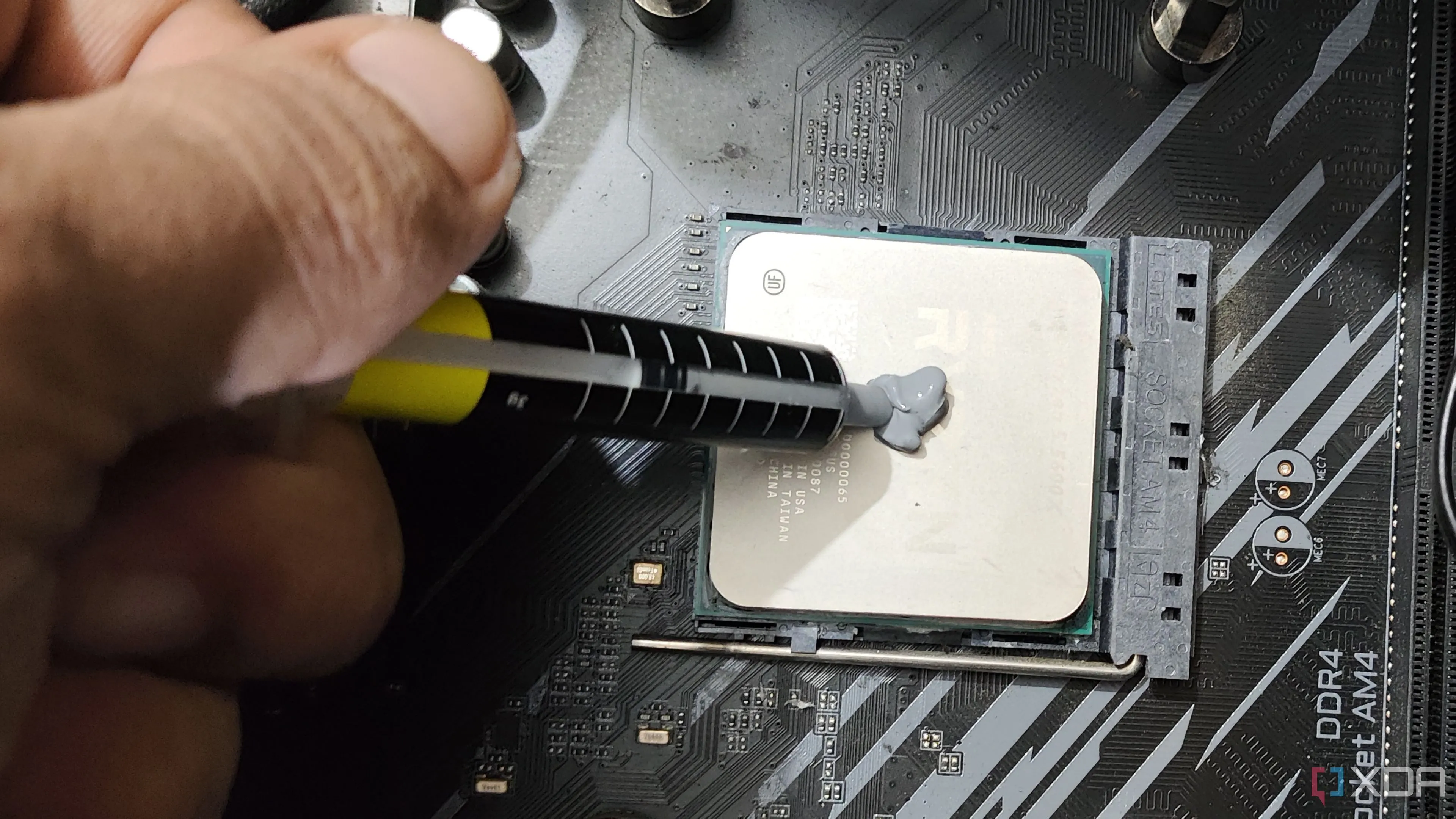 Người dùng đang bôi keo tản nhiệt lên bộ vi xử lý Ryzen 5 5600X