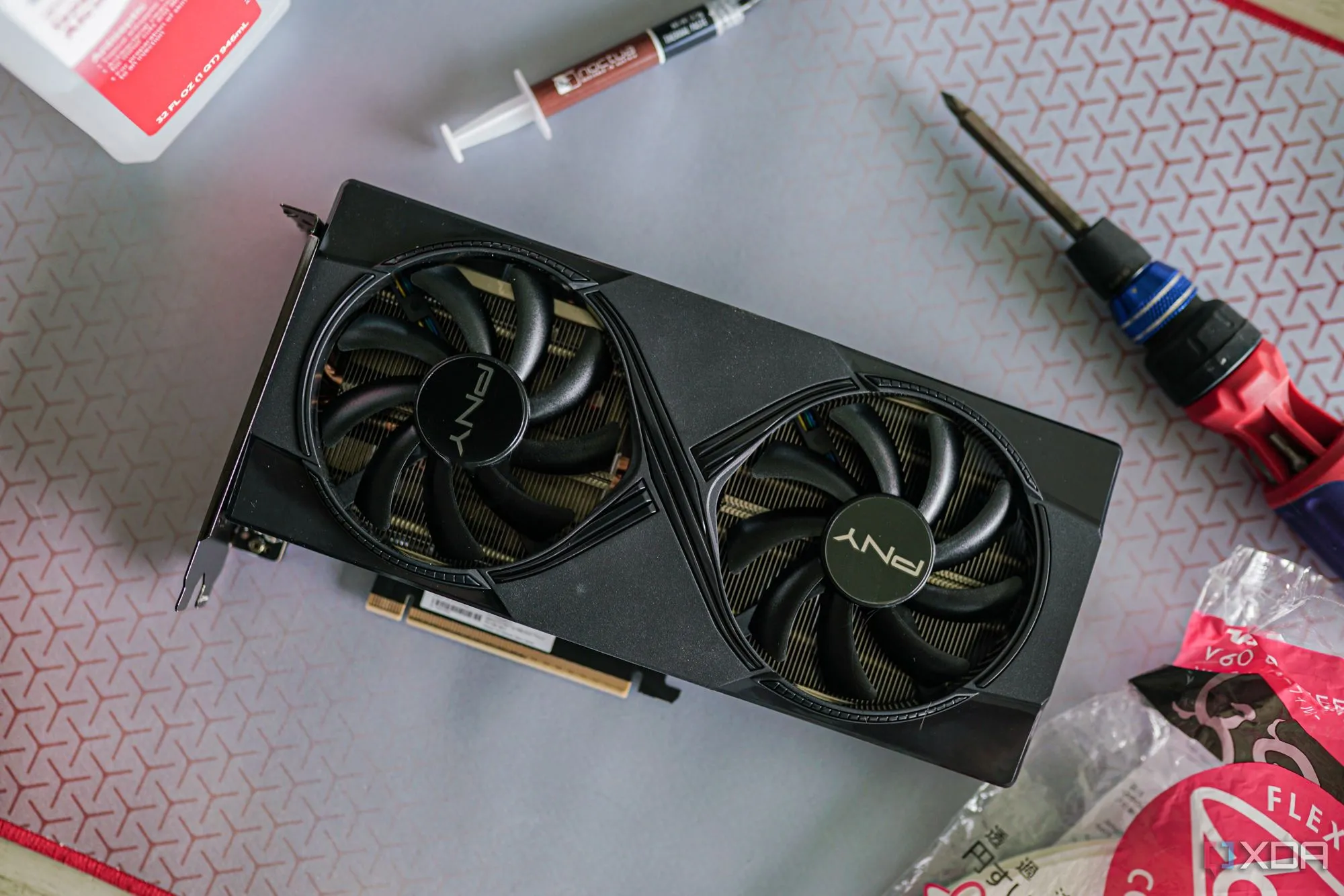 Thao tác thay keo tản nhiệt trên card đồ họa (GPU), biểu thị việc bảo trì và nâng cấp các linh kiện PC.