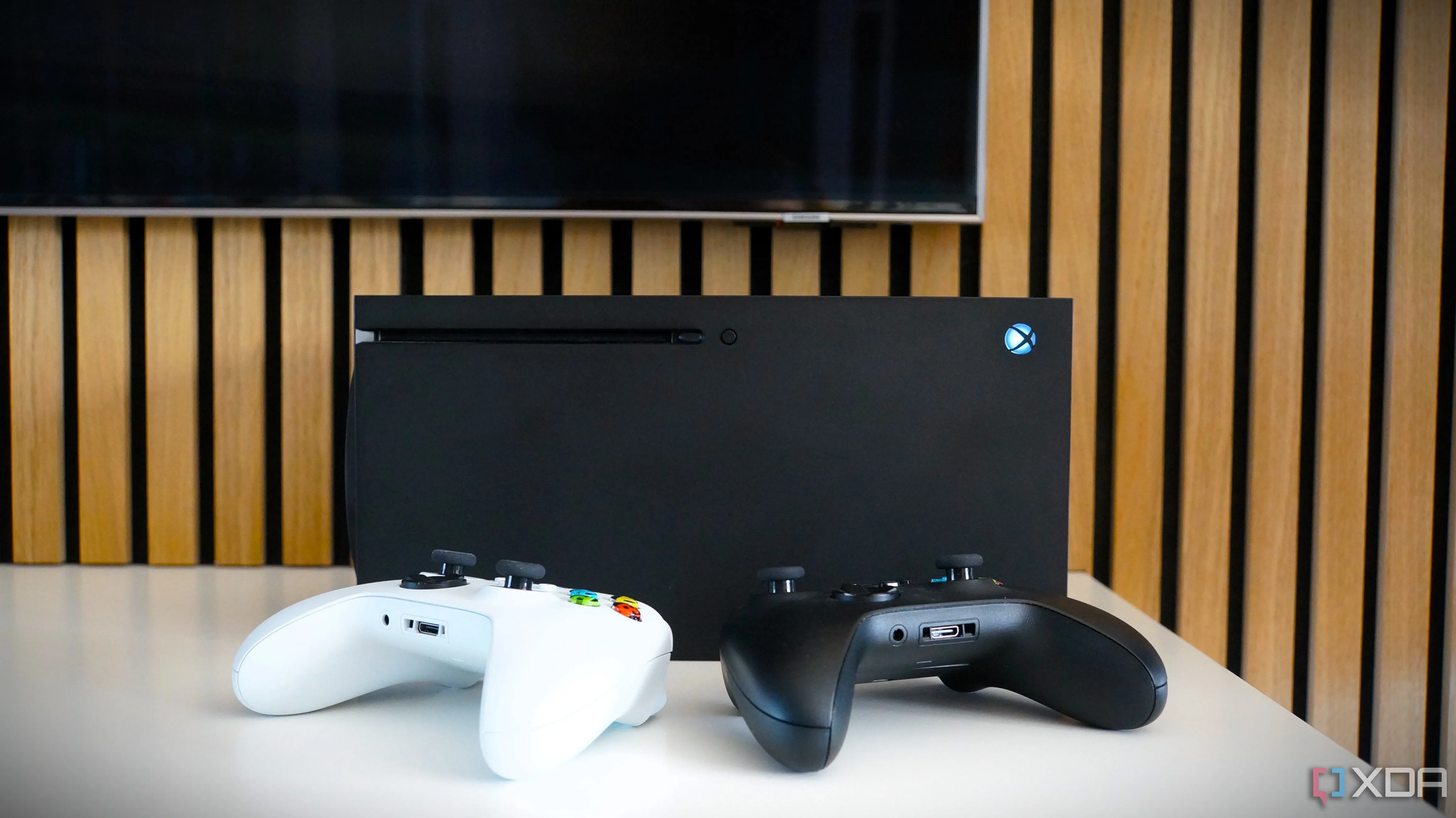 TV Samsung hiển thị giao diện Xbox, cùng với bộ điều khiển và console Xbox Series X